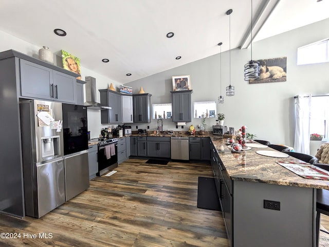 kitchen featuring sink, wall chimney exhaust hood, pendant lighting, gray cabinets, and appliances with stainless steel finishes