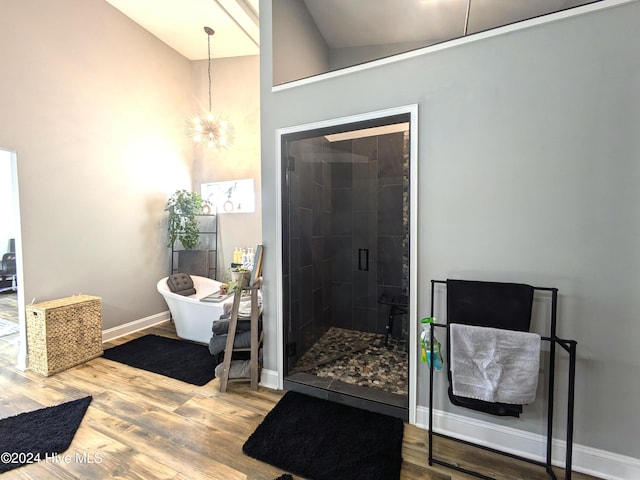 bathroom featuring plus walk in shower, a chandelier, lofted ceiling, and hardwood / wood-style flooring