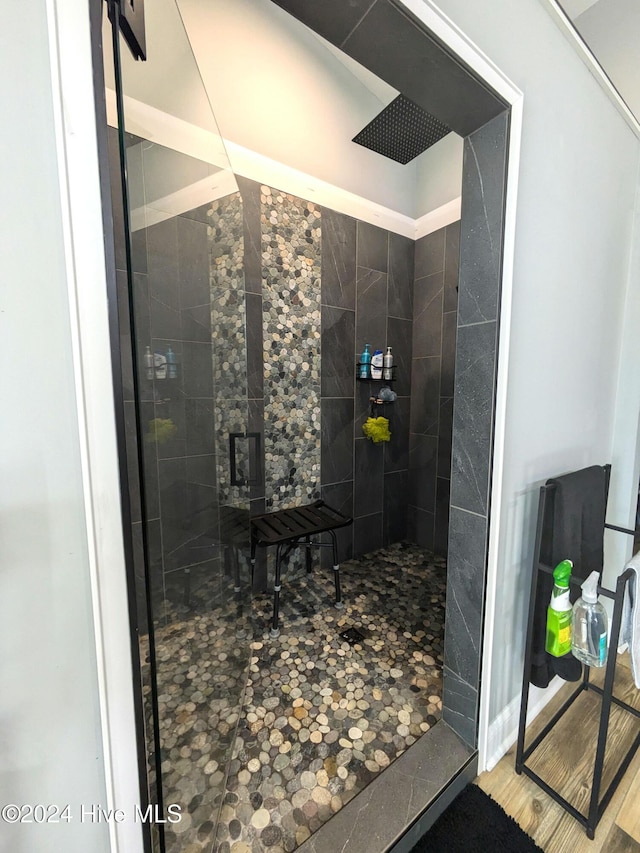 bathroom featuring hardwood / wood-style floors and a tile shower