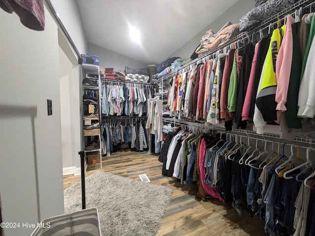 walk in closet with hardwood / wood-style floors and lofted ceiling