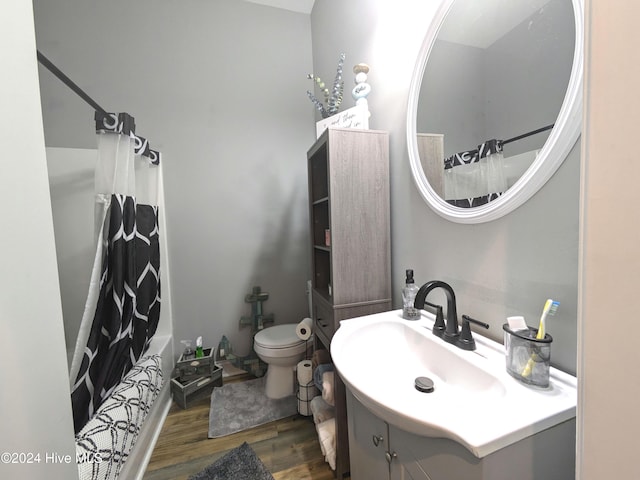 full bathroom with hardwood / wood-style floors, vanity, toilet, and shower / bathtub combination with curtain