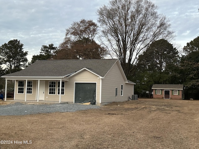 view of front facade featuring an outbuilding, a porch, and central AC