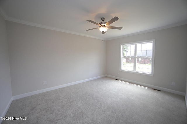 spare room with light carpet, ceiling fan, and crown molding