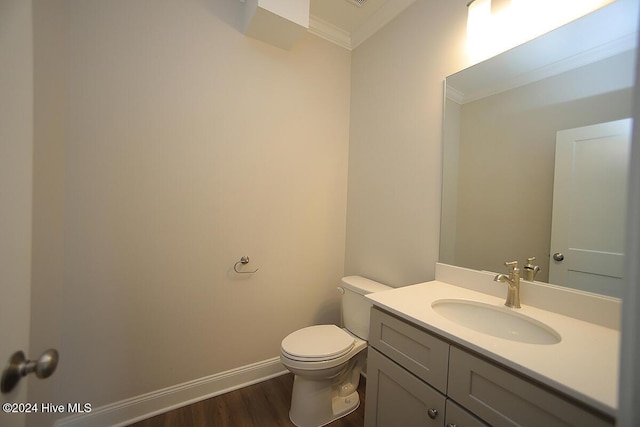 bathroom with hardwood / wood-style floors, vanity, toilet, and crown molding