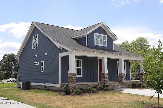 craftsman-style home featuring a front lawn, central AC unit, and a porch