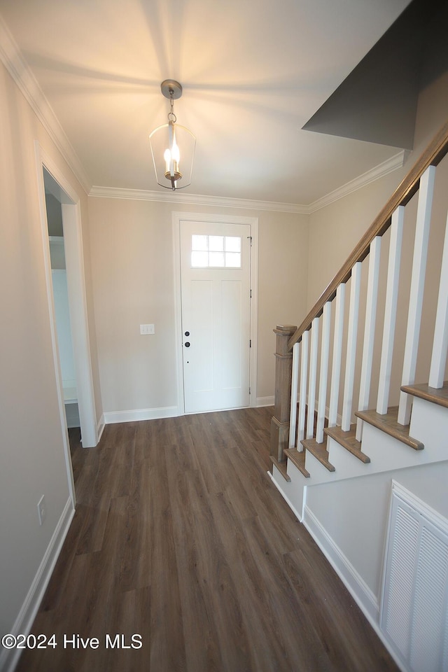 entrance foyer with dark hardwood / wood-style floors, ornamental molding, and a notable chandelier