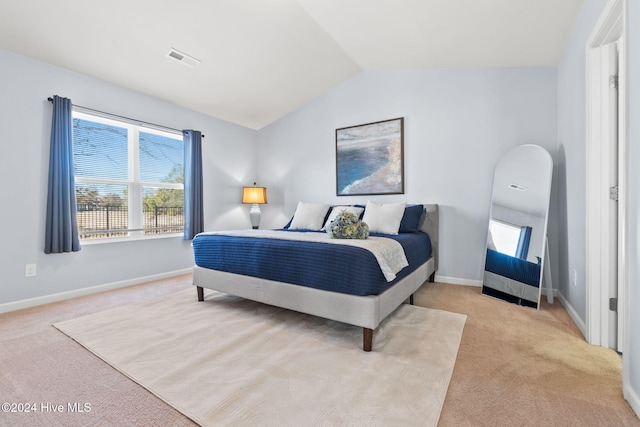 carpeted bedroom with visible vents, lofted ceiling, and baseboards