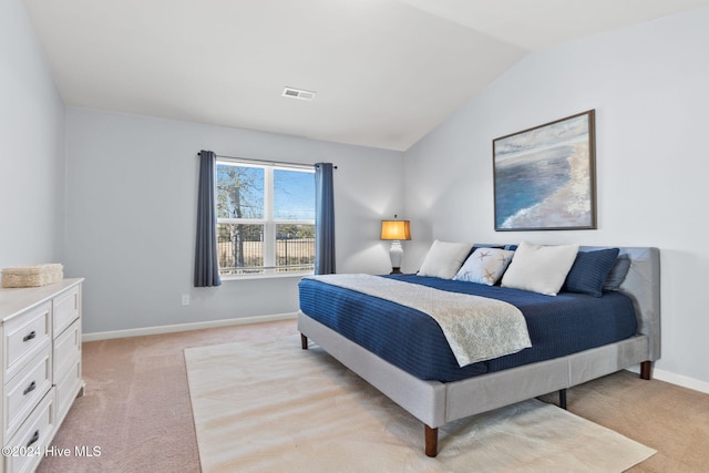 bedroom featuring vaulted ceiling, visible vents, baseboards, and light carpet