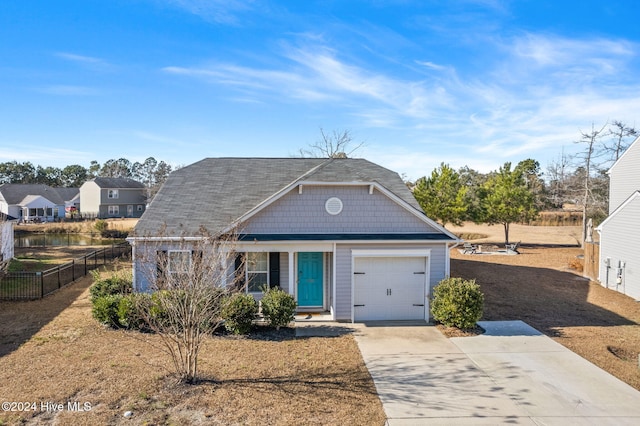 view of front of home featuring an attached garage, driveway, and fence