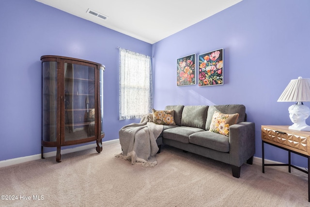 carpeted living area featuring baseboards and visible vents