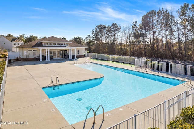 pool with fence and a patio area