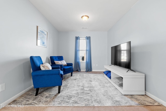 living area featuring carpet, visible vents, and baseboards