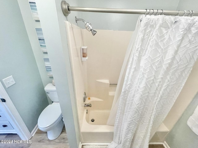 bathroom featuring hardwood / wood-style flooring, toilet, and shower / bathtub combination with curtain