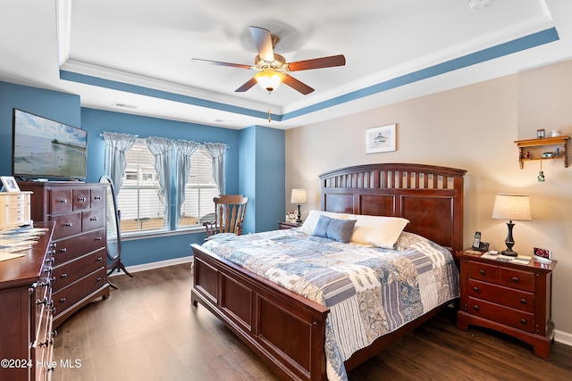 bedroom featuring dark hardwood / wood-style floors, a raised ceiling, ceiling fan, and ornamental molding