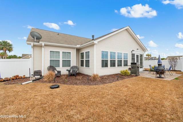 rear view of house featuring a patio and a lawn