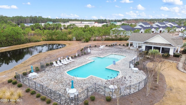 view of swimming pool with a patio area and a water view