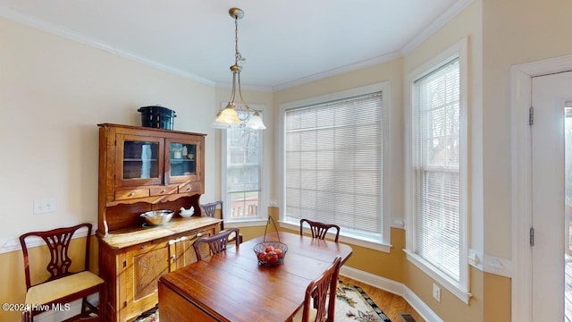 dining room featuring wood-type flooring and crown molding