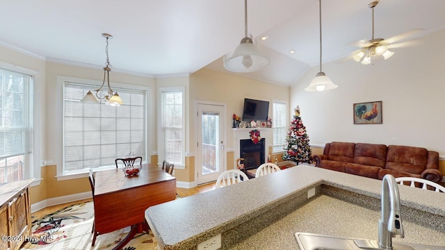 interior space featuring lofted ceiling, ceiling fan with notable chandelier, sink, light wood-type flooring, and ornamental molding