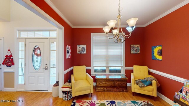 interior space featuring ornamental molding, wood-type flooring, and an inviting chandelier