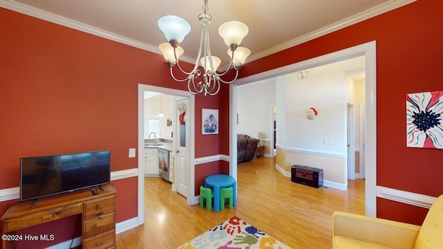 playroom with hardwood / wood-style floors, sink, crown molding, and an inviting chandelier