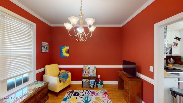 recreation room featuring a notable chandelier, light wood-type flooring, and crown molding