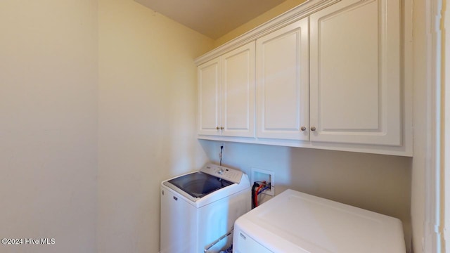 washroom featuring separate washer and dryer and cabinets