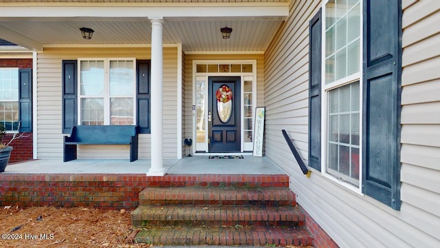 view of exterior entry with a porch