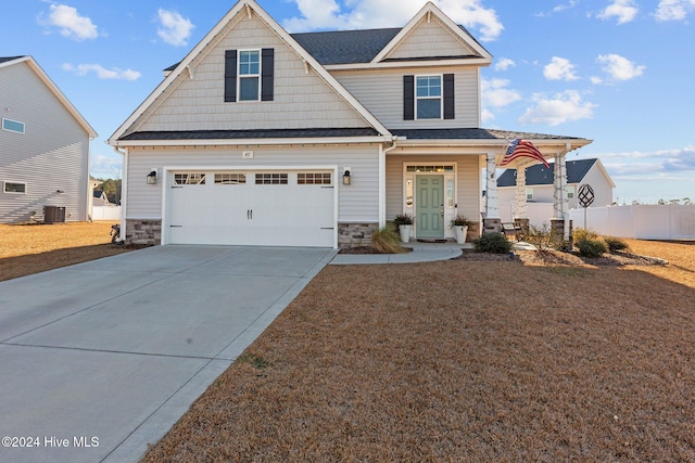 craftsman inspired home with central air condition unit and a garage