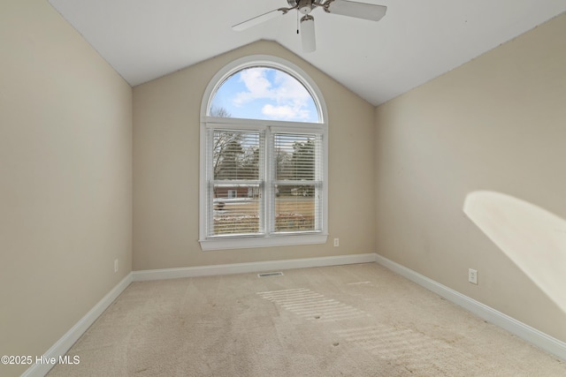 carpeted spare room featuring ceiling fan and vaulted ceiling