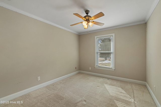 carpeted spare room with ceiling fan and ornamental molding