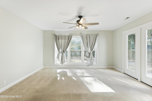 spare room featuring ceiling fan and light colored carpet