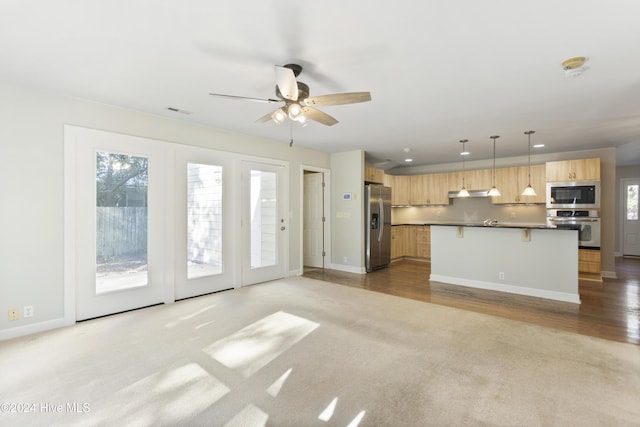 unfurnished living room with ceiling fan and light colored carpet