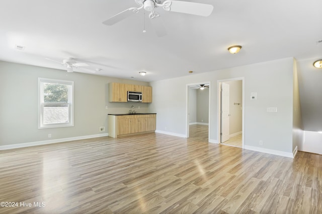 unfurnished living room featuring light hardwood / wood-style flooring and sink