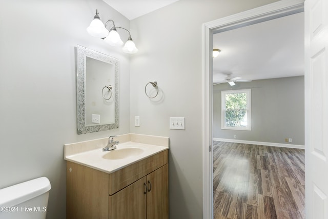 bathroom with vanity, hardwood / wood-style flooring, toilet, and ceiling fan