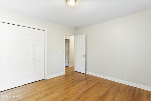 unfurnished bedroom featuring a closet and light hardwood / wood-style flooring