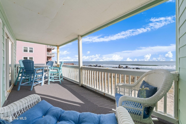 balcony featuring a beach view and a water view