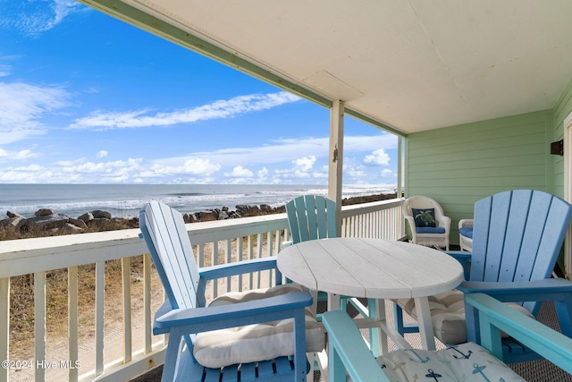 balcony featuring a beach view and a water view