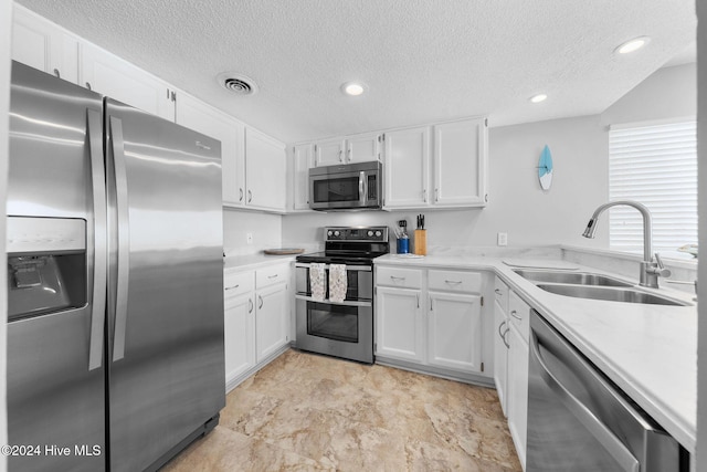 kitchen featuring sink, white cabinets, a textured ceiling, and appliances with stainless steel finishes