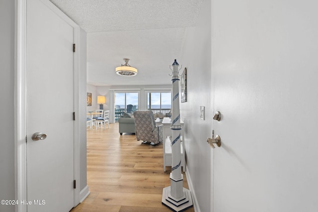 hallway featuring a textured ceiling and light hardwood / wood-style flooring