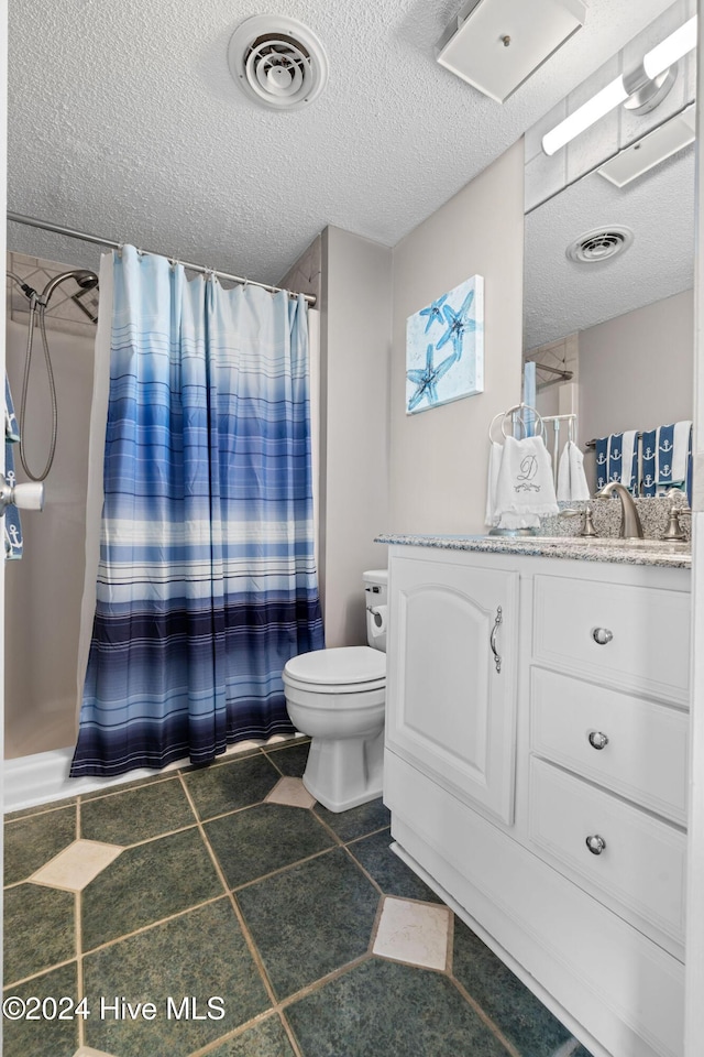 bathroom with a shower with curtain, vanity, toilet, and a textured ceiling