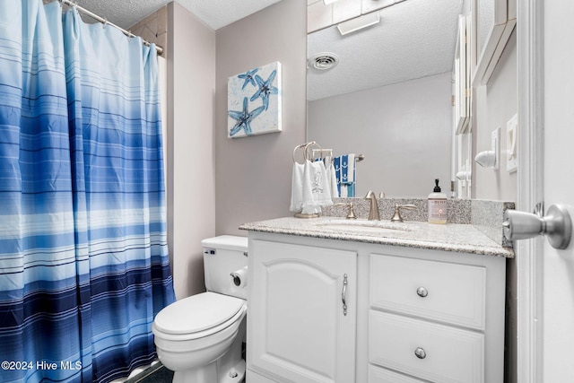 bathroom with vanity, toilet, and a textured ceiling