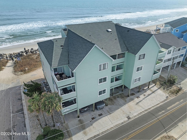 birds eye view of property featuring a water view and a beach view