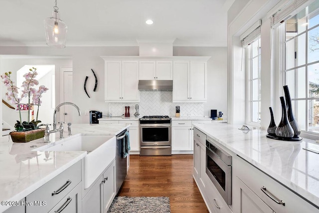 kitchen with pendant lighting, white cabinets, light stone countertops, and stainless steel appliances