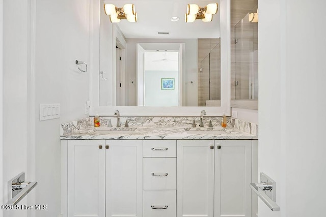 bathroom with vanity and a shower with shower door