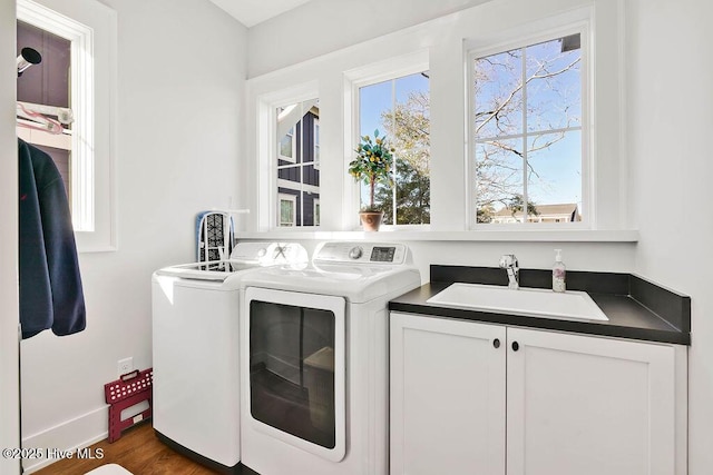 washroom with separate washer and dryer, sink, cabinets, and dark hardwood / wood-style floors