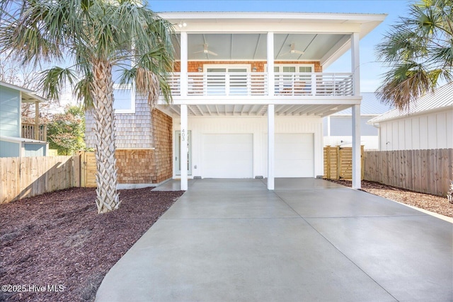 view of front of property featuring ceiling fan, a balcony, and a garage