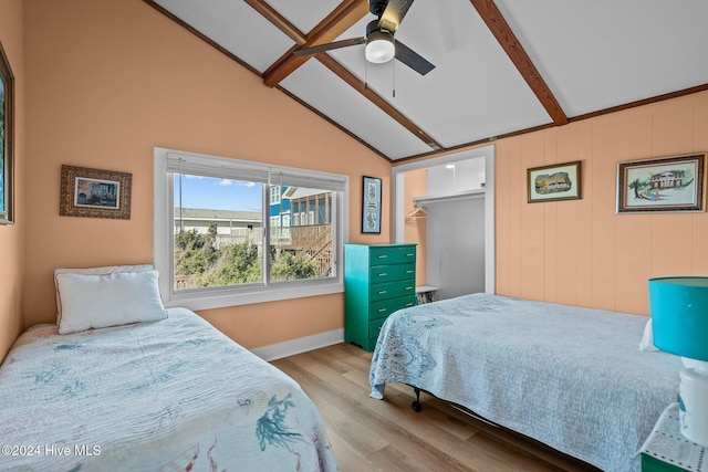 bedroom featuring vaulted ceiling with beams, light wood-type flooring, a closet, and ceiling fan