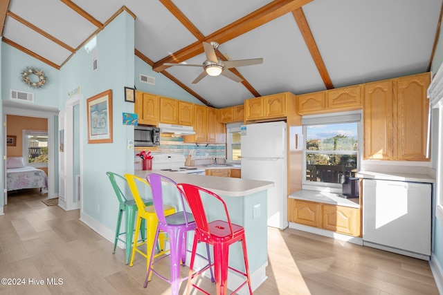 kitchen with backsplash, white refrigerator, sink, range, and a breakfast bar area