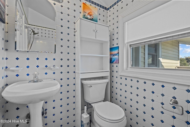 bathroom featuring toilet and tile walls