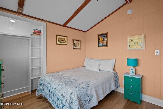 bedroom with hardwood / wood-style floors and vaulted ceiling with beams